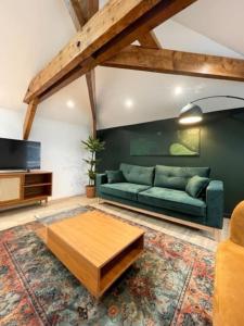 een woonkamer met een groene bank en een salontafel bij Suite Théodore - 2 pers in Charleville-Mézières