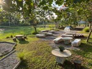 un parco con panchine e tavoli in erba di บ้าน guh (กูว์) a Uthai Thani