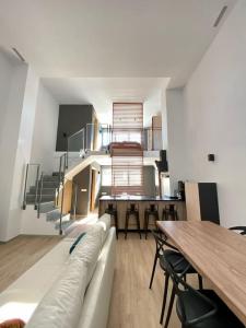 sala de estar con sofá, mesa y escaleras en WeRentVLC - Amazing Duplex Loft 2 bdrm en Valencia