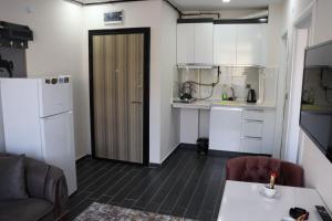 a kitchen with white cabinets and a table and a refrigerator at Loft Palace Suit in Nevşehir