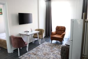 um quarto de hotel com uma televisão e uma mesa e cadeiras em Loft Palace Suit em Nevşehir