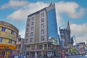 a tall building with glass windows on a city street at Hotel SRI SRI EXECUTIVE KOLHAPUR NEAR MAHALAXMI TEMPLE in Kolhapur