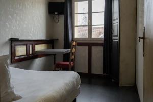 a room with a bed and a desk and a window at LA FERME D'ANDRE 