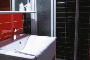La salle de bains est pourvue d'un lavabo blanc et d'un mur rouge. dans l'établissement LA FERME D'ANDRE, 