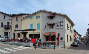 a building with people sitting outside of it on a street at LA FERME D'ANDRE in Saint-Jean-de-Bournay