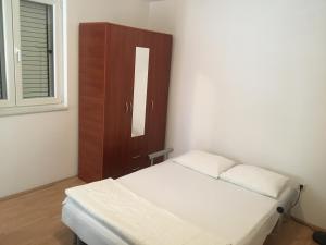 a small bedroom with a bed and a cabinet at Home Apartment Petrovac in Petrovac na Moru