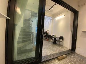 a reflection of a staircase in a glass window at Hanoi All Nations Homestay in Hanoi