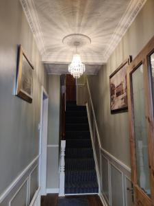 pasillo con escalera y lámpara de araña en Brads Pad -Ballymena Central- en Ballymena