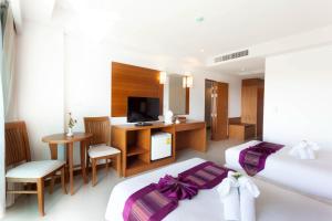 a hotel room with two beds and a television at Rawai Princess Hotel in Rawai Beach