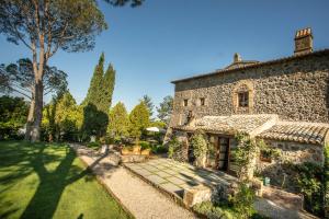 una vista esterna di una casa in pietra con giardino di Luxury Villa - Torre Collevento - Orvieto a Orvieto