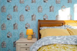 a bedroom with blue birdcages on the wall at Comfy Cumbrian Stay in Distington