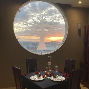 a table with a tree painted on the wall at Hotel Ceibo Dorado in Portoviejo