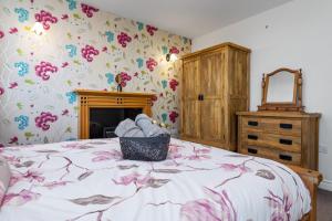 una camera da letto con un letto e carta da parati floreale di Comfy Cumbrian Stay a Distington