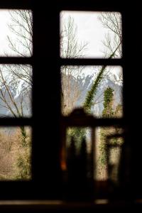 uma janela com vista para um jardim visto através dele em Villa MYLOS Kalavrita em Kalavrita