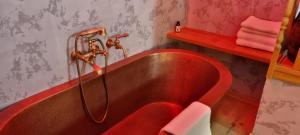 een rode badkuip in een badkamer met een rode wastafel bij U Medvidku-Brewery Hotel in Praag