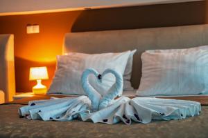 2 cigni fatti di asciugamani su un letto di Hotel Oasis a Mostar