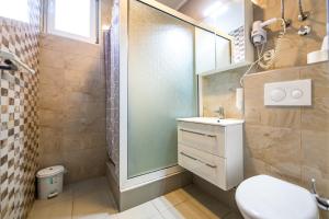 een badkamer met een douche, een toilet en een wastafel bij Hotel Oasis in Mostar