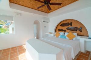 a bedroom with a bed with a ceiling fan at Marina del Sol Resort & Yacht Club in Busuanga +15 photos