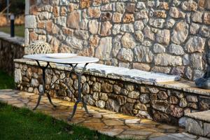 a table sitting in front of a stone wall at Villa MYLOS Kalavrita in Kalavrita