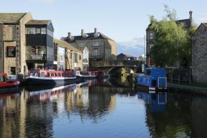a group of boats in a river in a city at Moor View in Skipton
