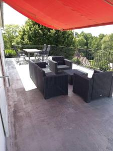 a patio with tables and chairs and a red umbrella at La Grimpette in Châtillon-en-Bazois