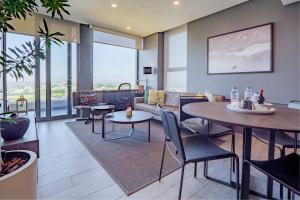 a living room with tables and chairs and a couch at Umhlanga Arch Luxury Holiday or Work with Sea View - Inverter Backup Power in Durban