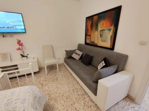 ein Wohnzimmer mit einem Sofa und einem TV in der Unterkunft Sergio's Rooms & Studio close Tiburtina Station in Rom