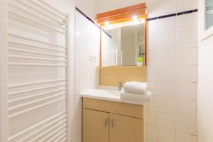 ein Bad mit einem Waschbecken und einem Spiegel in der Unterkunft Appart'City Classic Lyon Villeurbanne in Villeurbanne