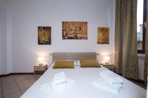 a bedroom with a large white bed with two lamps at Casato19 - Due passi da Piazza del Campo - NaonBnB in Siena