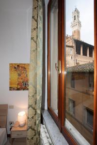a window in a room with a view of a building at Casato19 - Due passi da Piazza del Campo - NaonBnB in Siena