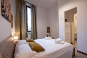 a bedroom with a bed with white sheets and a window at Casato19 - Due passi da Piazza del Campo - NaonBnB in Siena