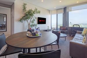a dining room with a table and a couch at Umhlanga Arch Luxury Holiday or Work with Sea View - Inverter Backup Power in Durban