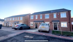 two cars parked in a parking lot in front of a brick building at Thorpe House - Home Crowd Luxury Apartments in Doncaster