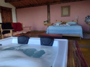 a room with a bath tub and a bed at Chalés Pôr do Sol in Gonçalves