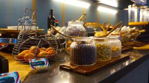 a counter with three jars of pickles and other ingredients at Hotel Indigo Madrid - Gran Vía by IHG in Madrid