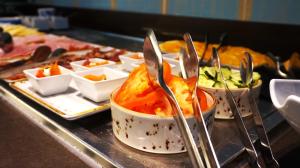 a buffet line with several dishes of food with forks at Hotel Indigo Madrid - Gran Vía by IHG in Madrid