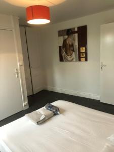 ein Schlafzimmer mit einem weißen Bett mit einer Tasche darauf in der Unterkunft Appartement cosy proximité plage Malo les bains in Dunkerque