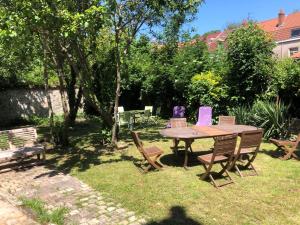 einen Holztisch und Stühle im Hof in der Unterkunft Appartement cosy proximité plage Malo les bains in Dunkerque