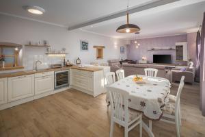 een keuken en een woonkamer met een tafel en stoelen bij Villa Sany in Heki