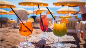 - trois cocktails en verres assis sur une table sur la plage dans l'établissement Village Club L'Oustal Del Mar, au Lavandou