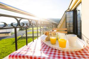 een dienblad met twee glazen sinaasappelsap op een tafel op een balkon bij Apartagal-Costa Reinante Spa in Barreiros
