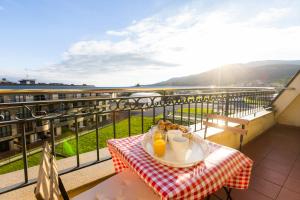 een tafel met een bord eten en drinken op een balkon bij Apartagal-Costa Reinante Spa in Barreiros