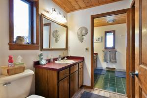 a bathroom with a sink and a mirror and a shower at Bark Point Retreat in Herbster +45 photos