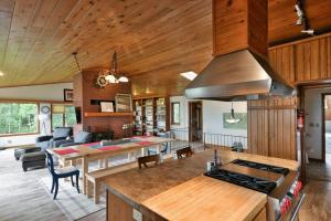 a kitchen and living room with a stove top oven at Bark Point Retreat in Herbster