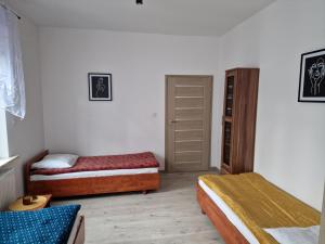 a bedroom with two beds and a closet at Noclegi Leśna in Leśna