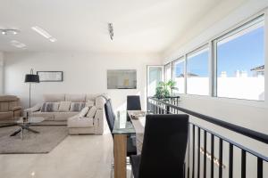 uma sala de estar com um sofá e uma mesa em Valle Romano Golf Resort Penthouse Apartmento em Estepona