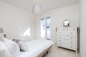 1 dormitorio blanco con 2 camas y vestidor en Valle Romano Golf Resort Penthouse Apartmento, en Estepona