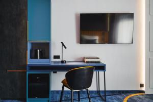 a blue desk with a chair and a mirror at Stay inn Hotel Warszawa in Warsaw