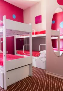 a room with two bunk beds and a mirror at Purple Nest Hostel in Valencia