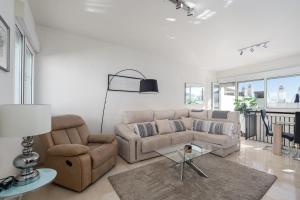sala de estar con sofá y silla en Valle Romano Golf Resort Penthouse Apartmento, en Estepona
